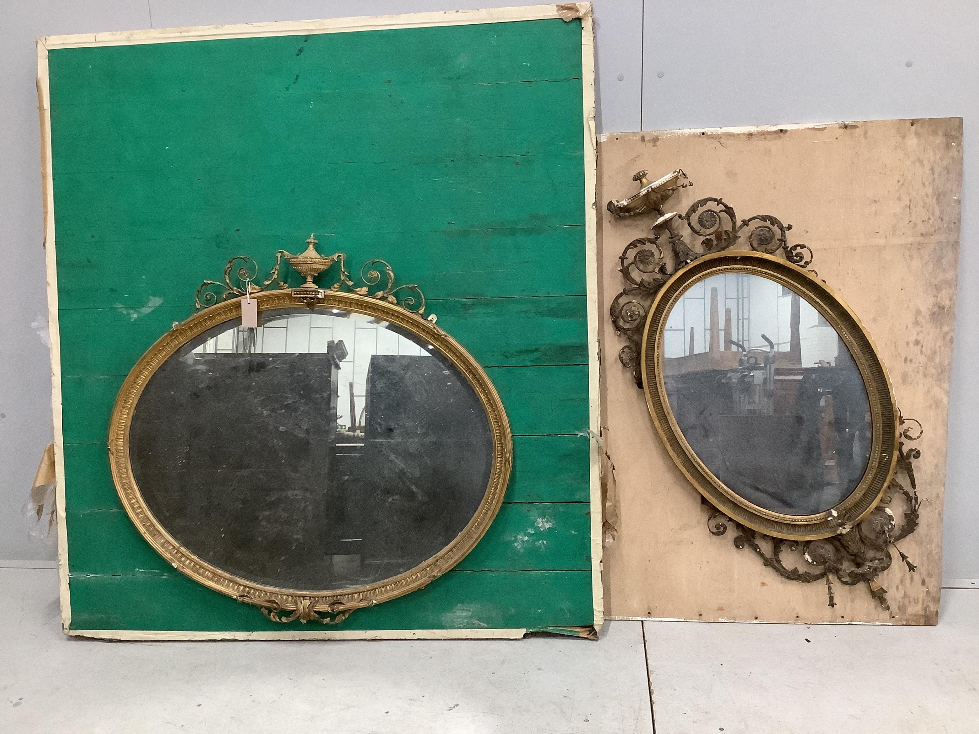 Two late Victorian / Edwardian Sheraton Revival oval giltwood and composition wall mirrors, larger width 100cm, height 95cm. Condition - poor to fair